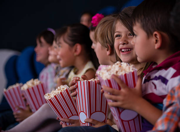  kids at the cinema eating popcorn